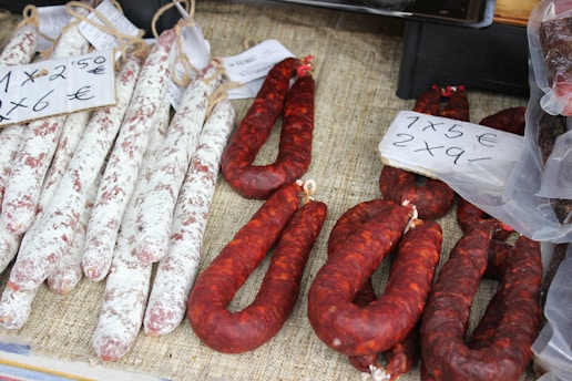 several sausages are on display for sale at a market