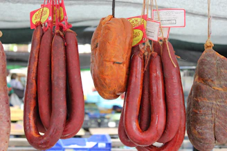 several sausages hanging from hooks in a market