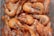 A close-up view of a pile of boiled shrimp with their shells still on, visible black eyes, and whiskers. The shrimp are laid out in a way that shows their pinkish-orange hue and shiny, slightly wet texture.