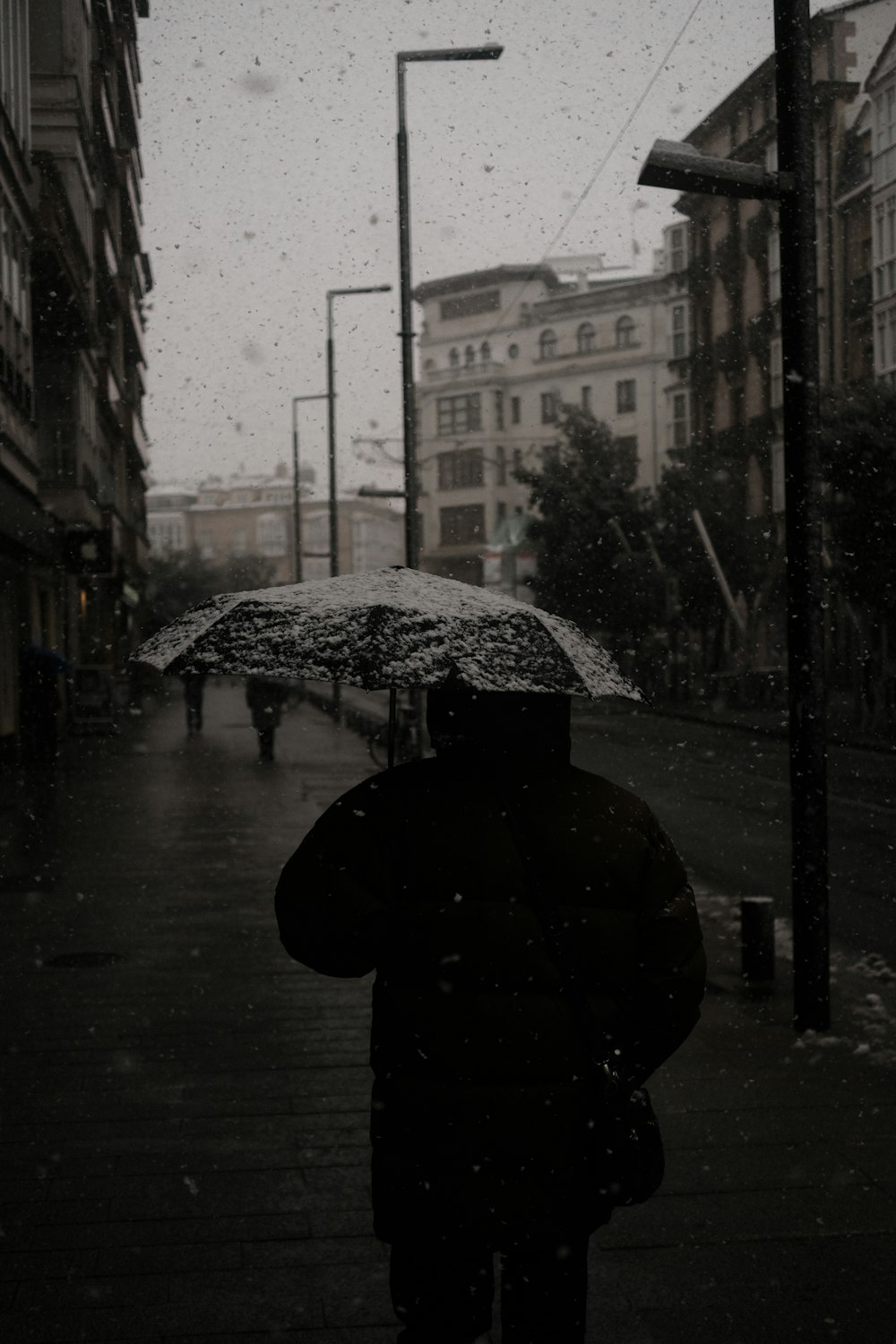 a person walking down a street holding an umbrella