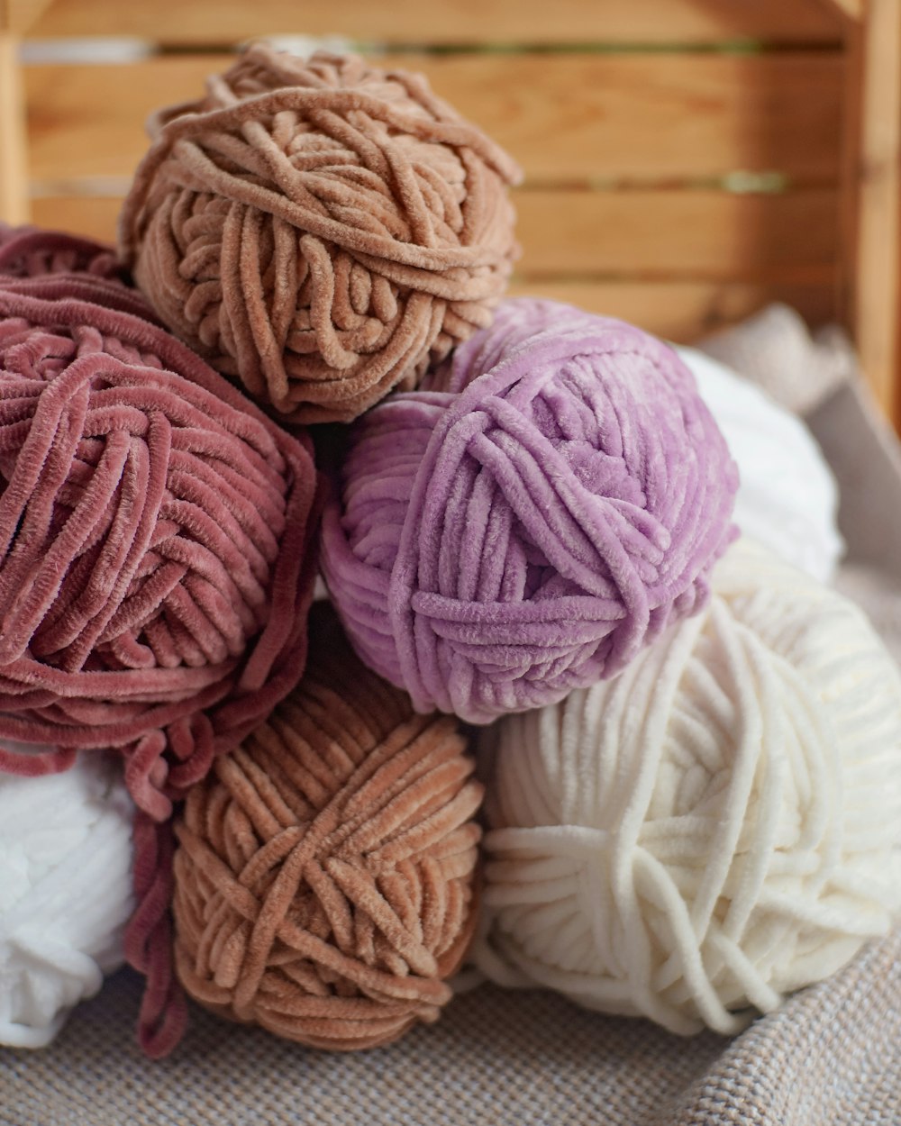 a pile of balls of yarn sitting on top of a bed