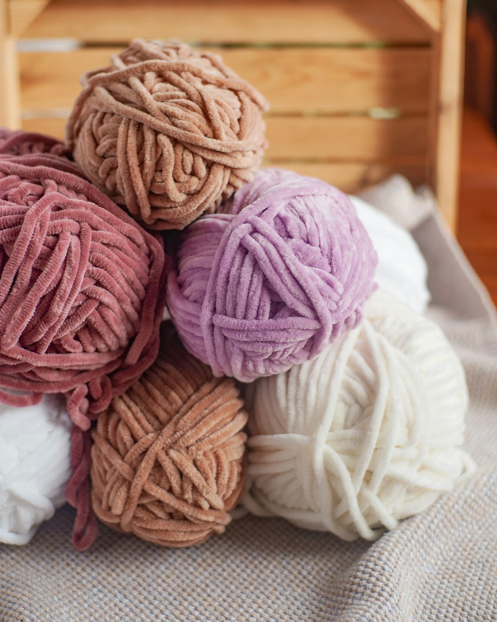 a pile of balls of yarn sitting on top of a bed