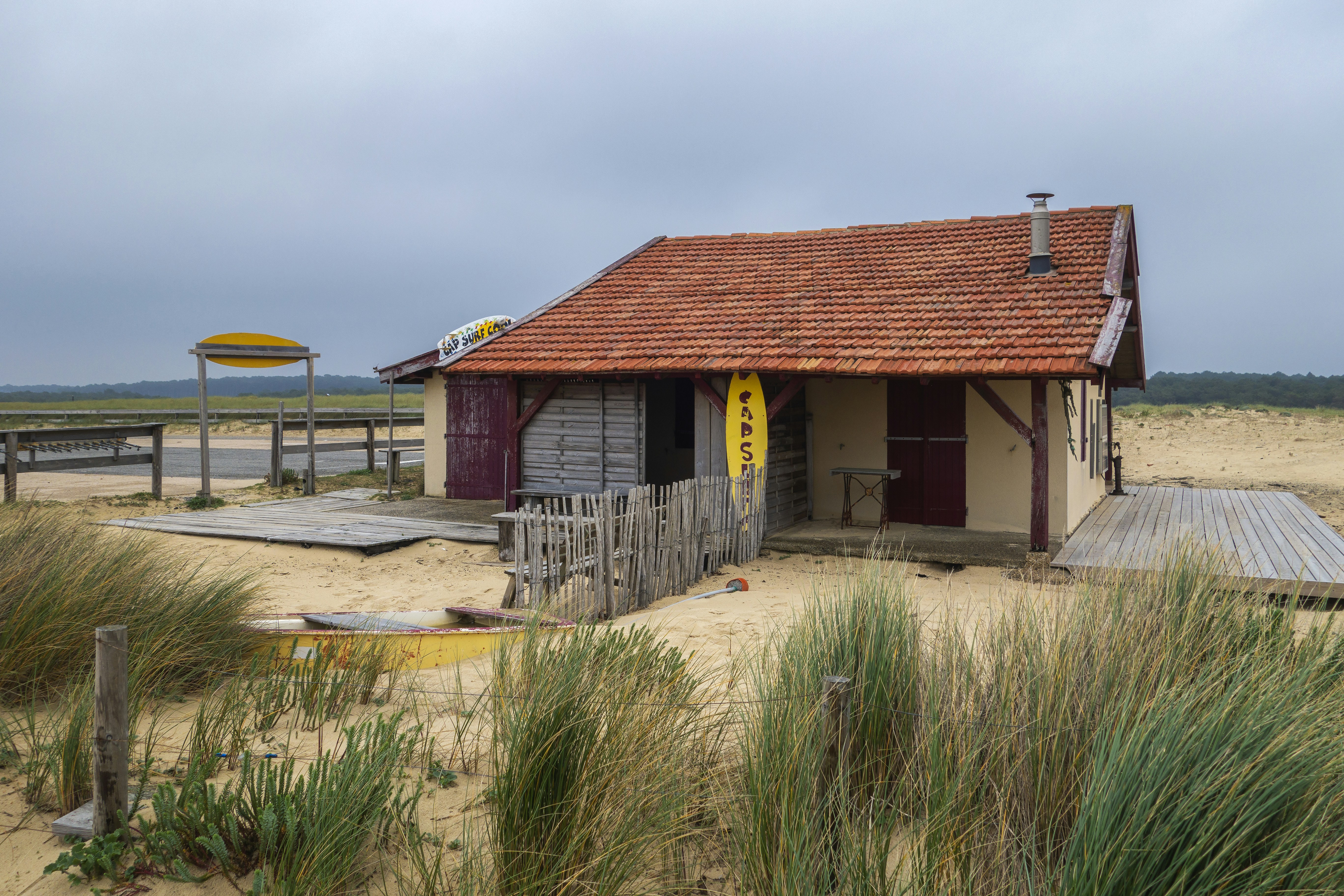a small building with a red roof on a beach