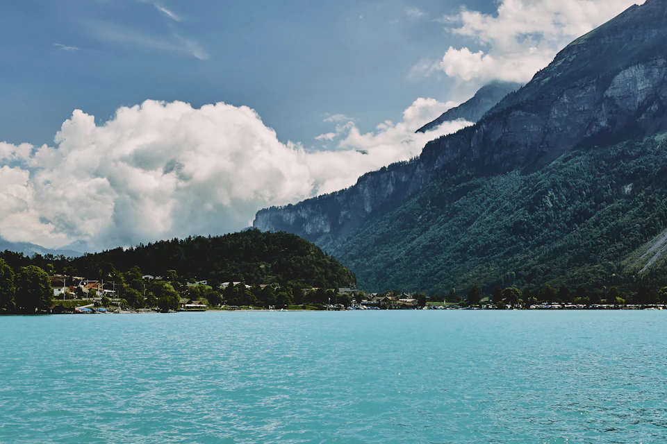 Serene mountain landscape with a deep blue lake surrounded by lush green trees and mountains