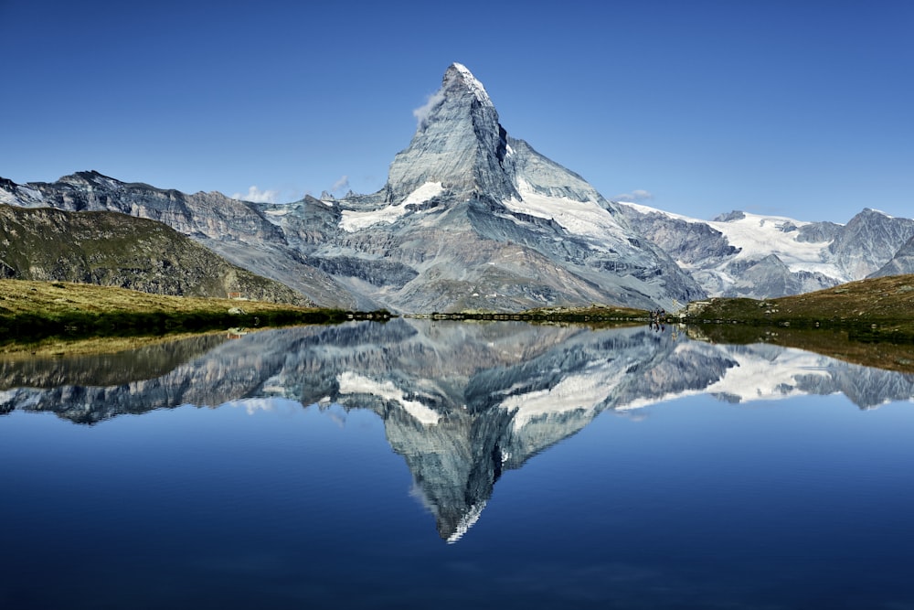 a mountain is reflected in the still water of a lake