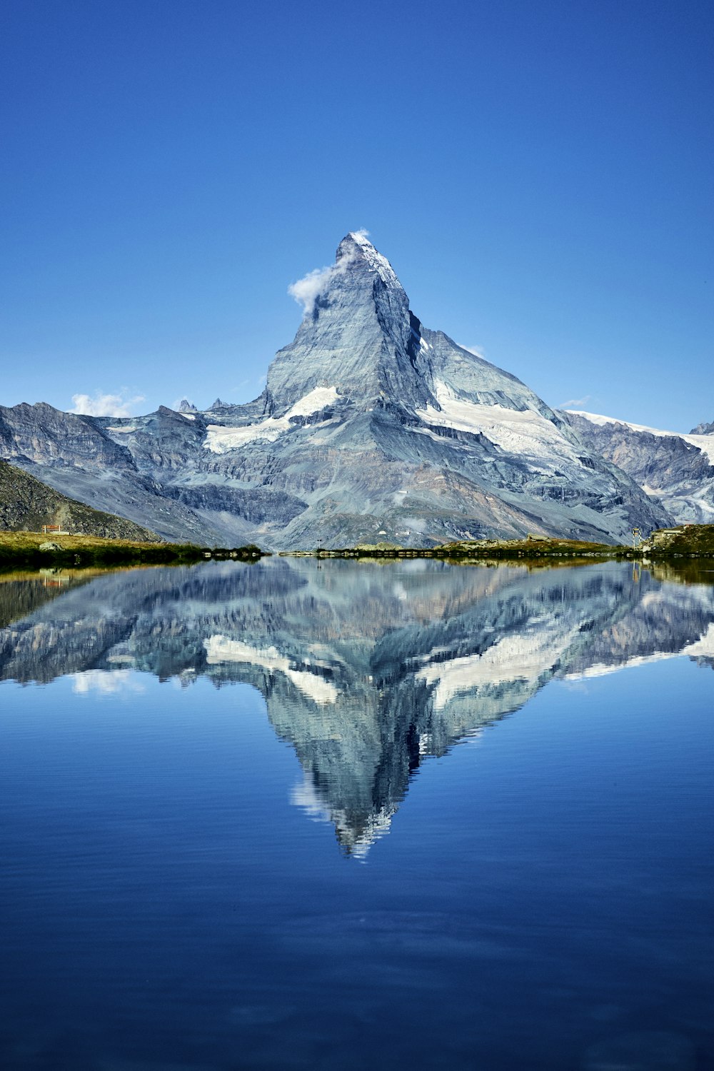 a mountain is reflected in the still water of a lake