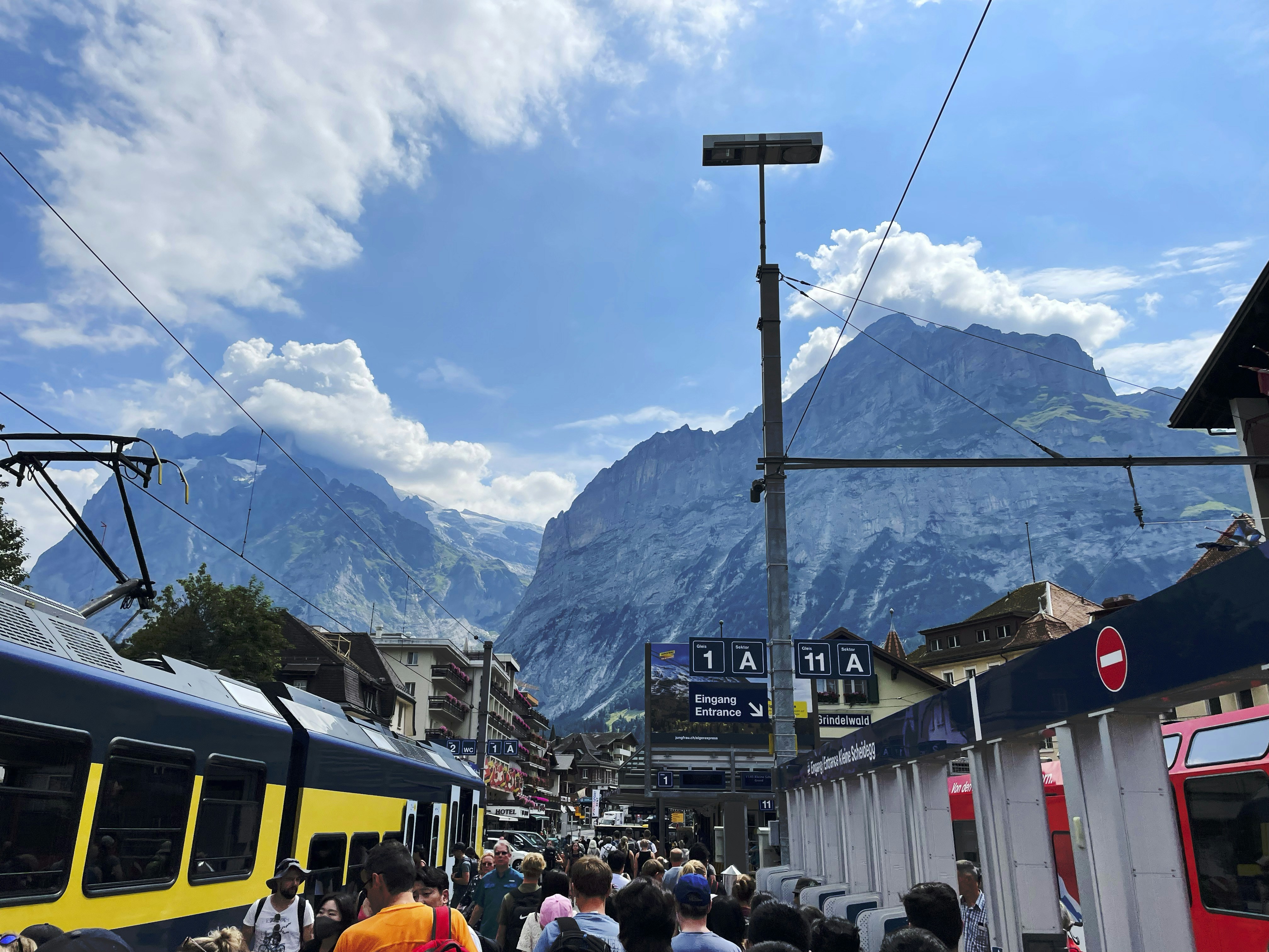 a crowd of people standing next to a train, 