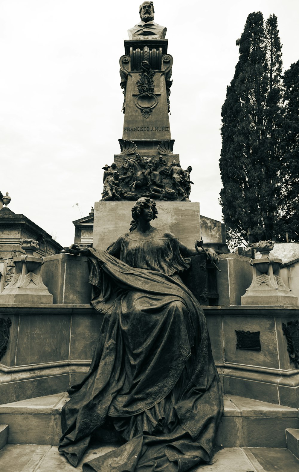 a statue of a woman sitting on top of a fountain