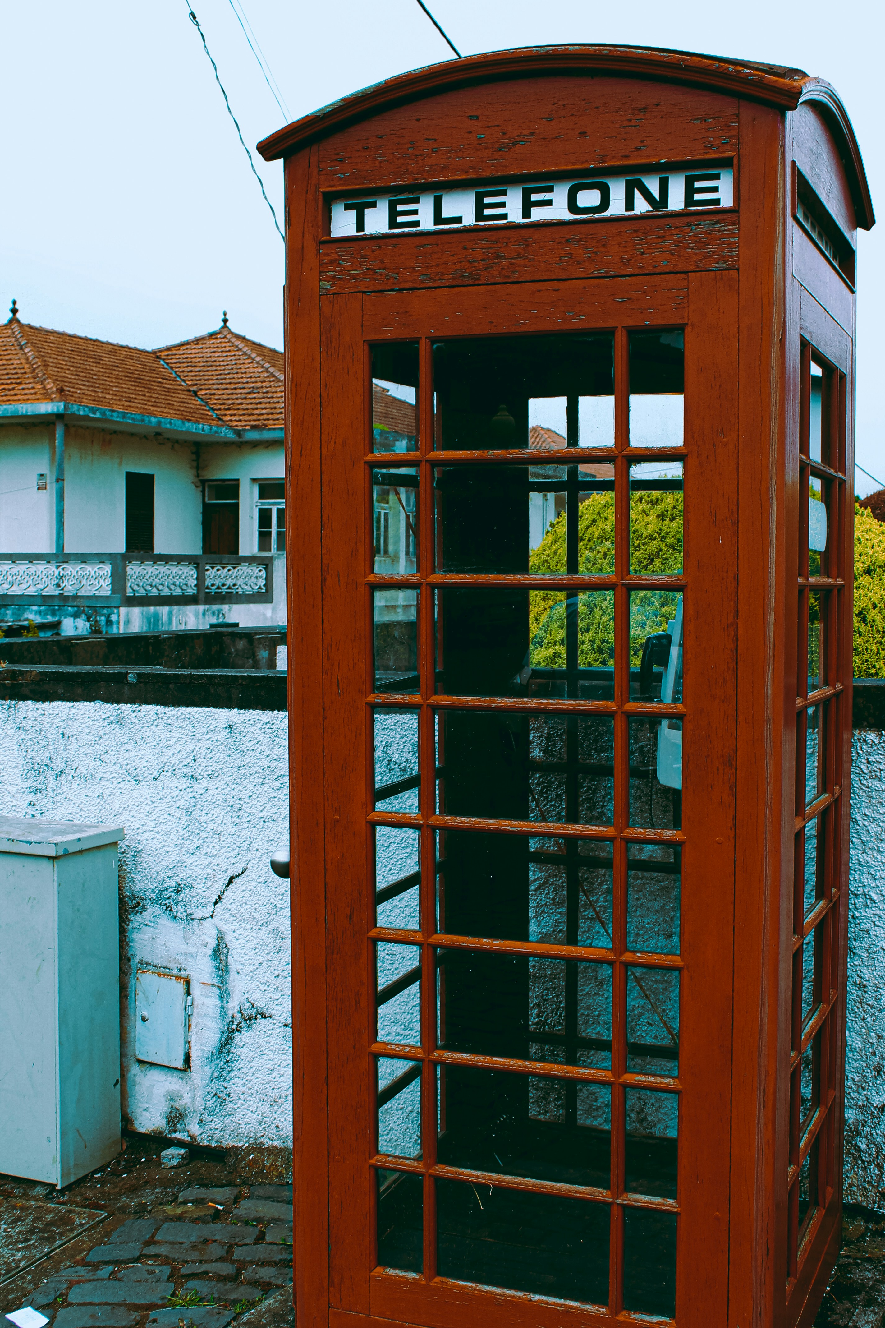 una cabina telefonica rossa seduta accanto a un edificio