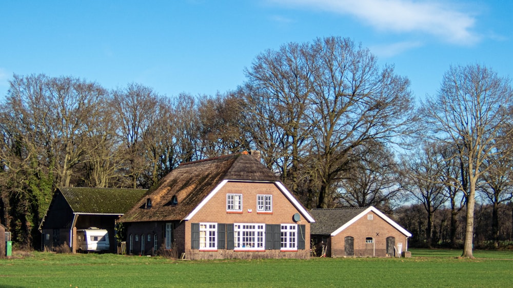 a house in a field with trees in the background
