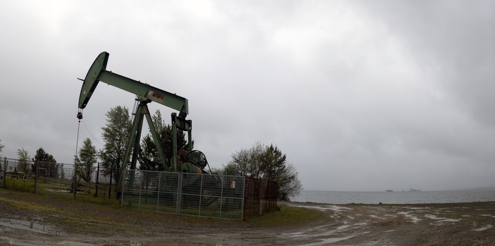 an oil pump sitting on top of a dirt field