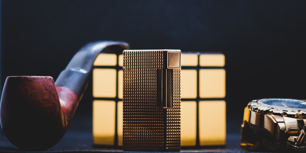 a pipe and a watch on a table