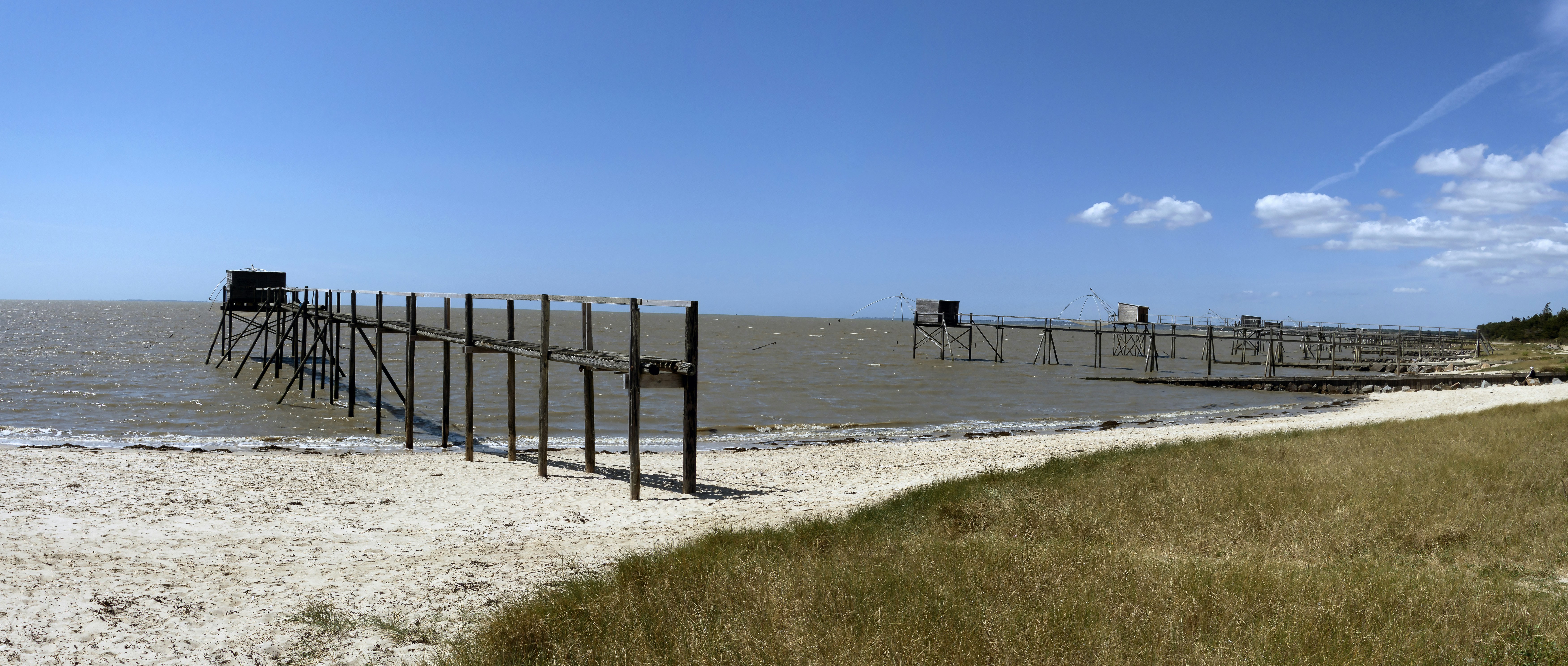 a-wooden-pier-sitting-on-top-of-a-sandy-beach-photo-free-c-te