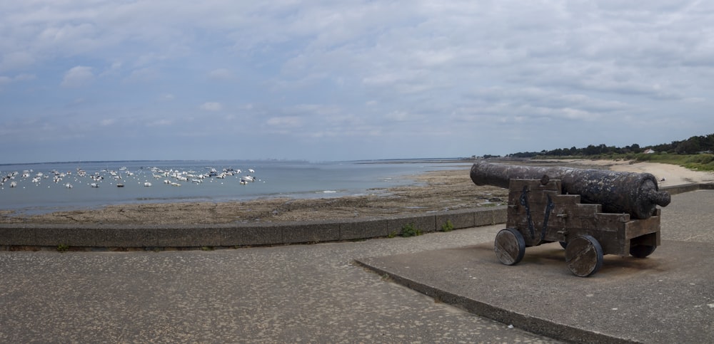 a cannon sitting on top of a cement wall near the ocean