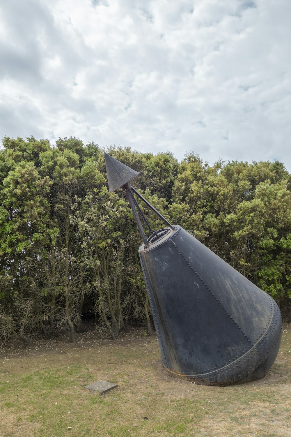 a large black object sitting in the middle of a field