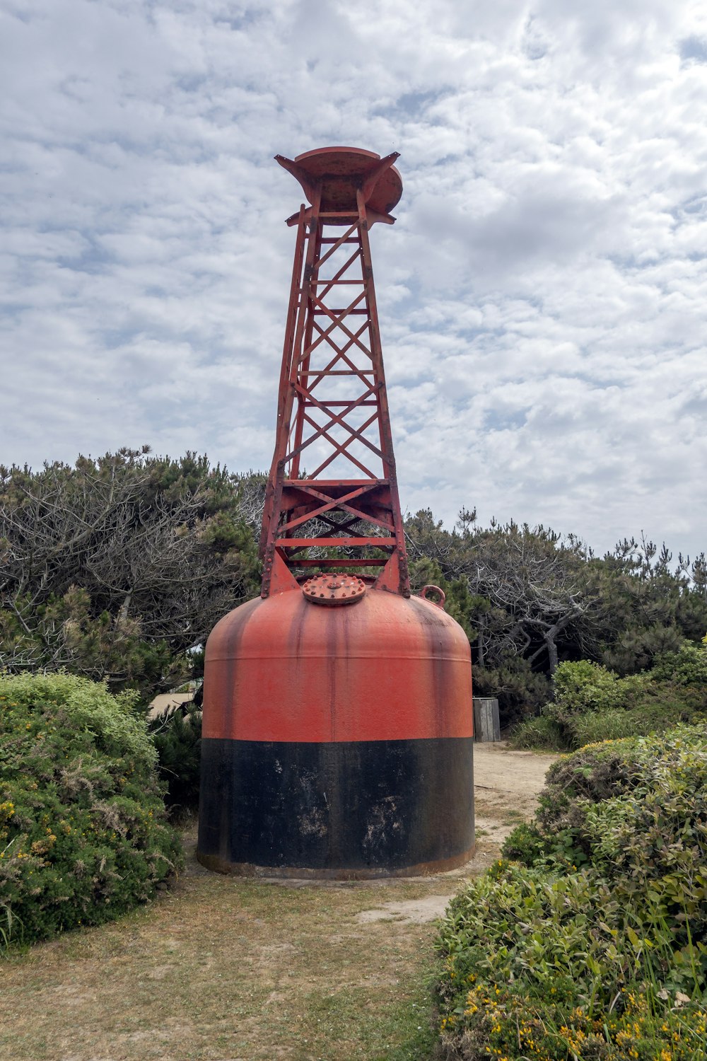 a large red and black object sitting in the middle of a field