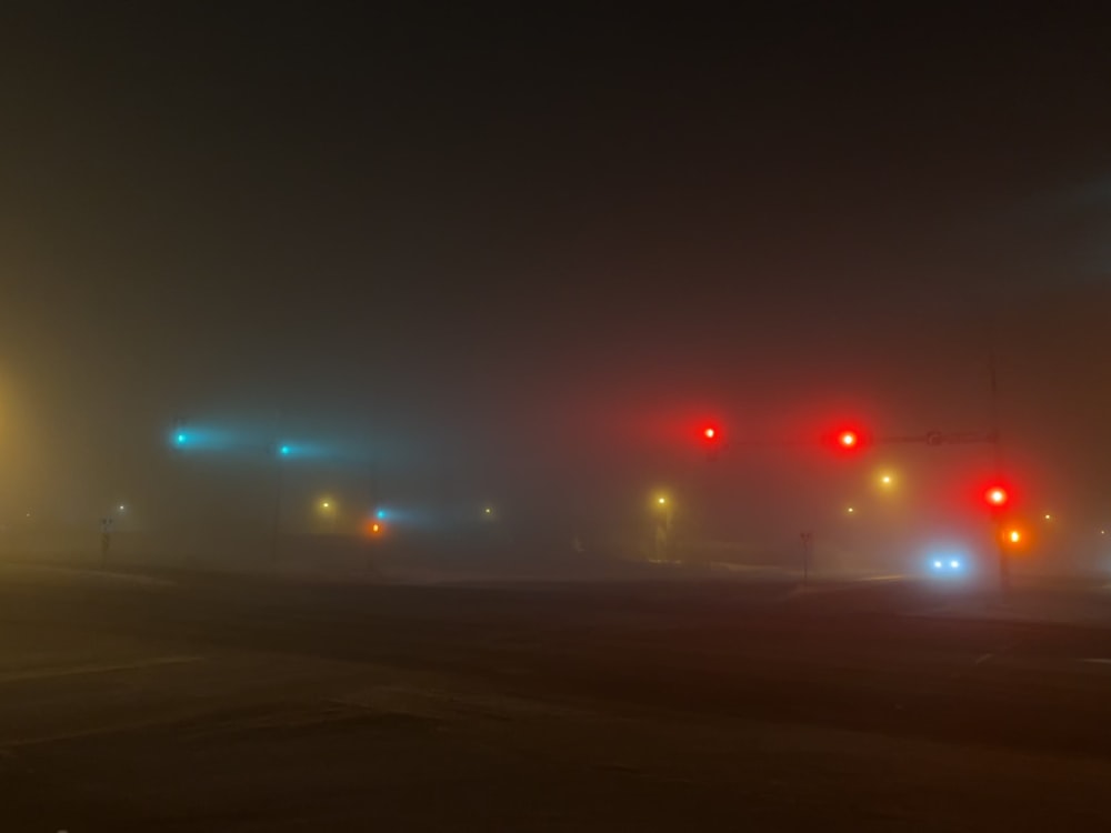 a foggy night with traffic lights and street signs
