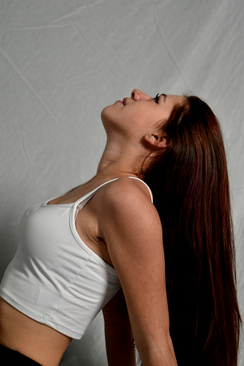 a woman in a white tank top and black shorts