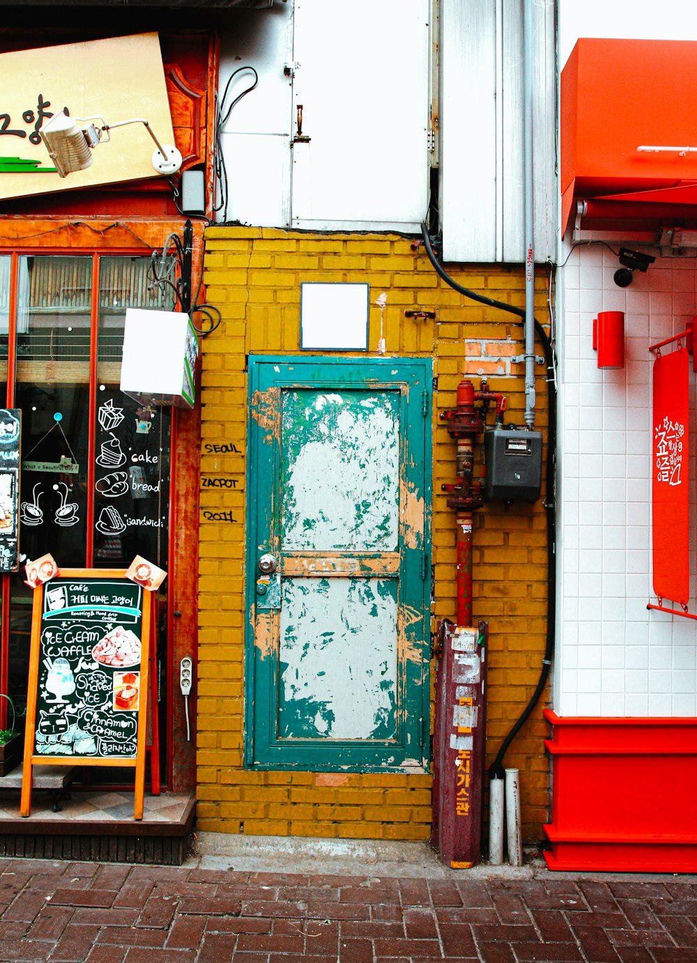 a yellow brick building with a green door