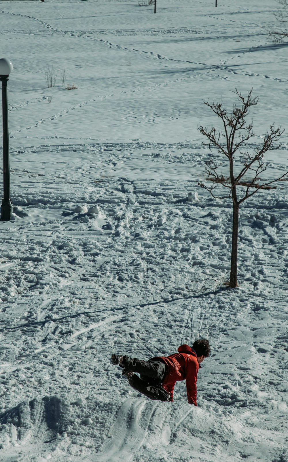 a man riding a snowboard down a snow covered slope