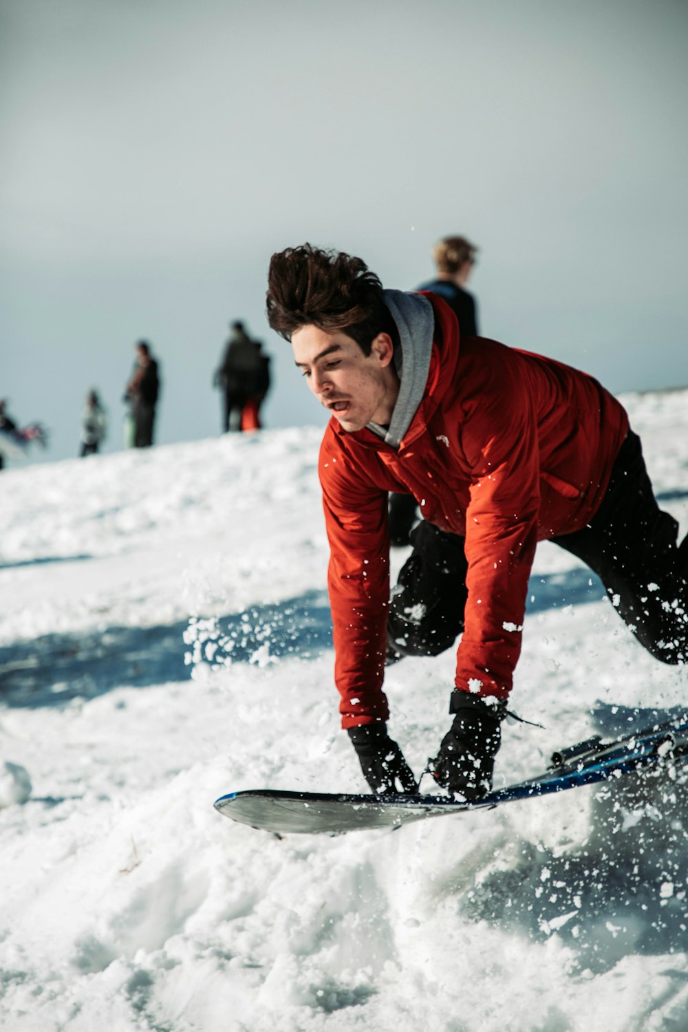 a man riding a snowboard down a snow covered slope