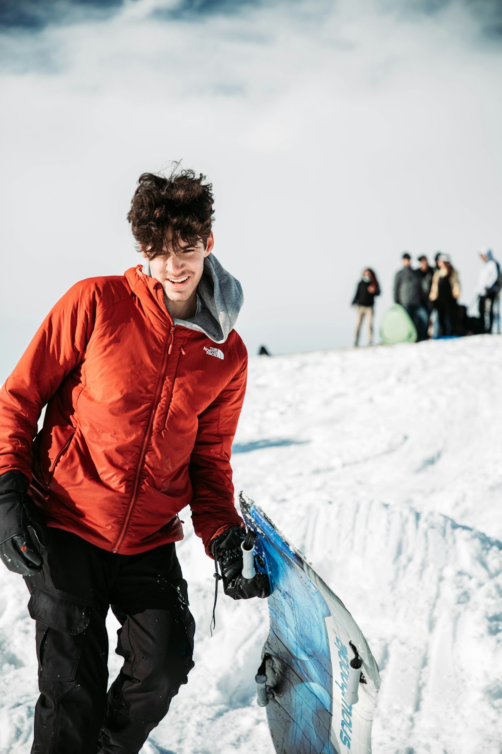 a man holding a snowboard on top of a snow covered slope