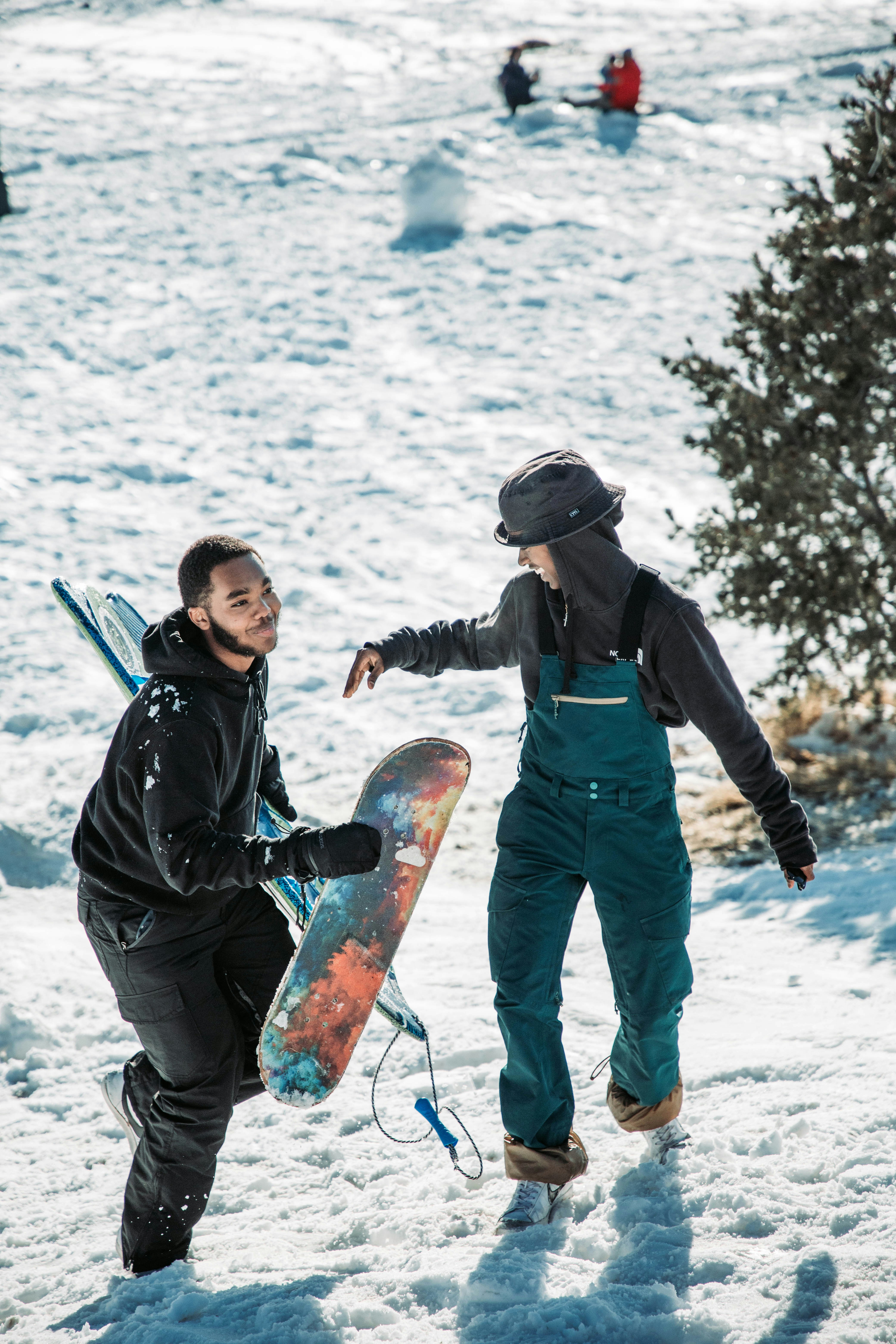 A man holding a snowboard next to another man photo – Free Portrait ...