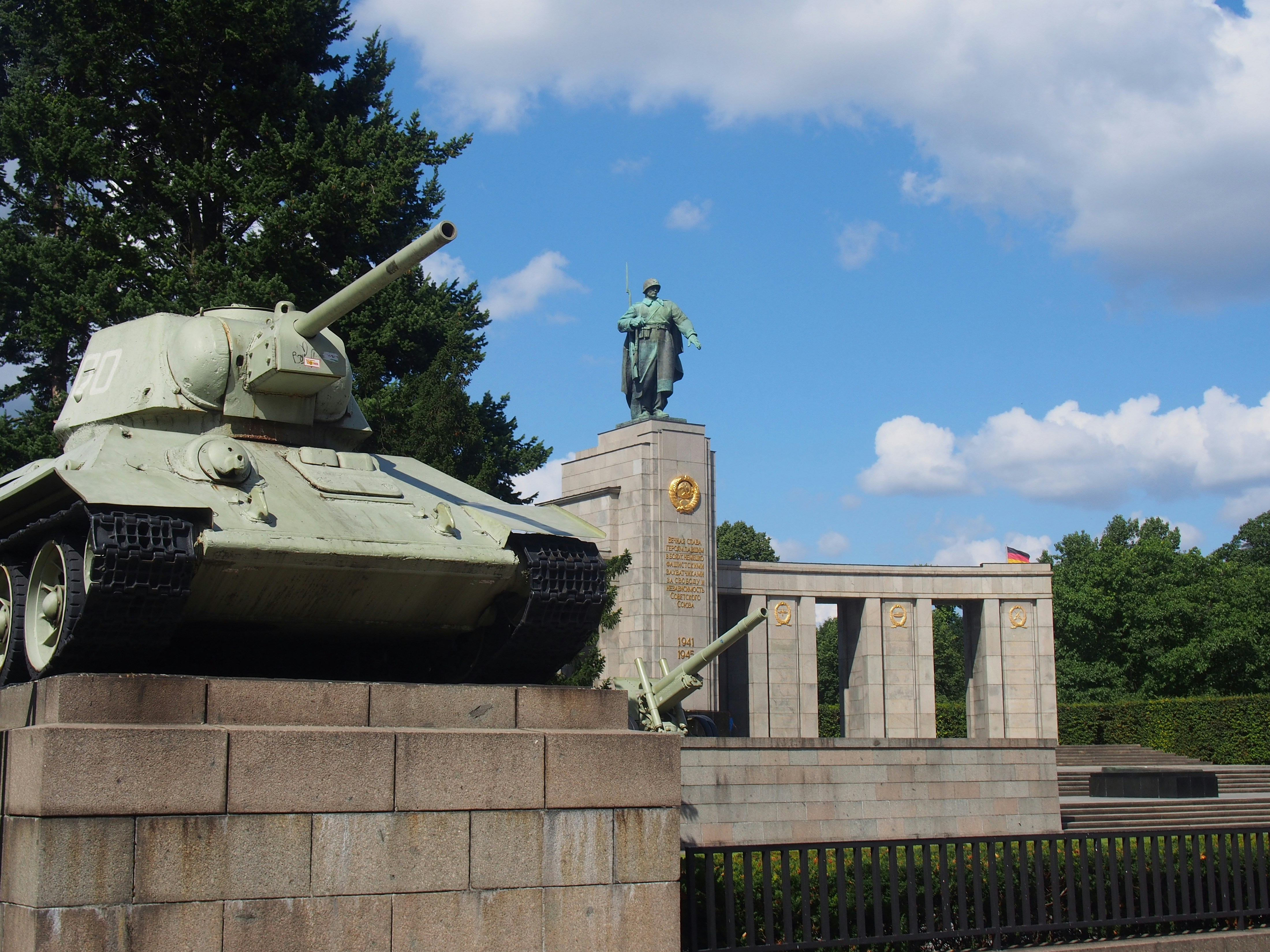 a statue of a man standing next to a tank