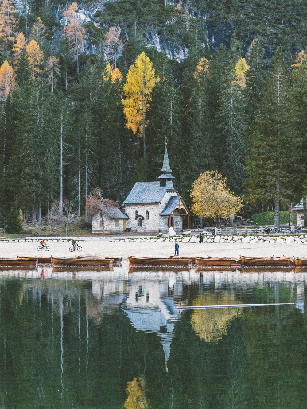 a small church on a lake surrounded by trees