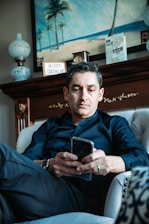 A friendly person typing a message on a smartphone with birthday-themed decor around