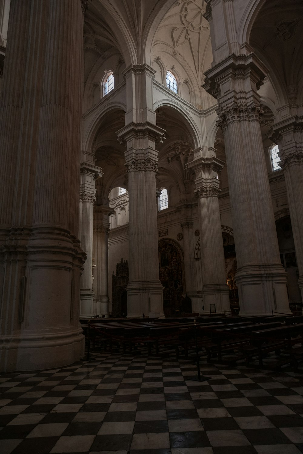 uma grande catedral com colunas e um piso quadriculado