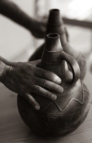 Close-up of hands inspecting handcrafted Indian goods with care.