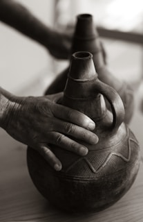 A close-up of hands holding traditional African crafts.