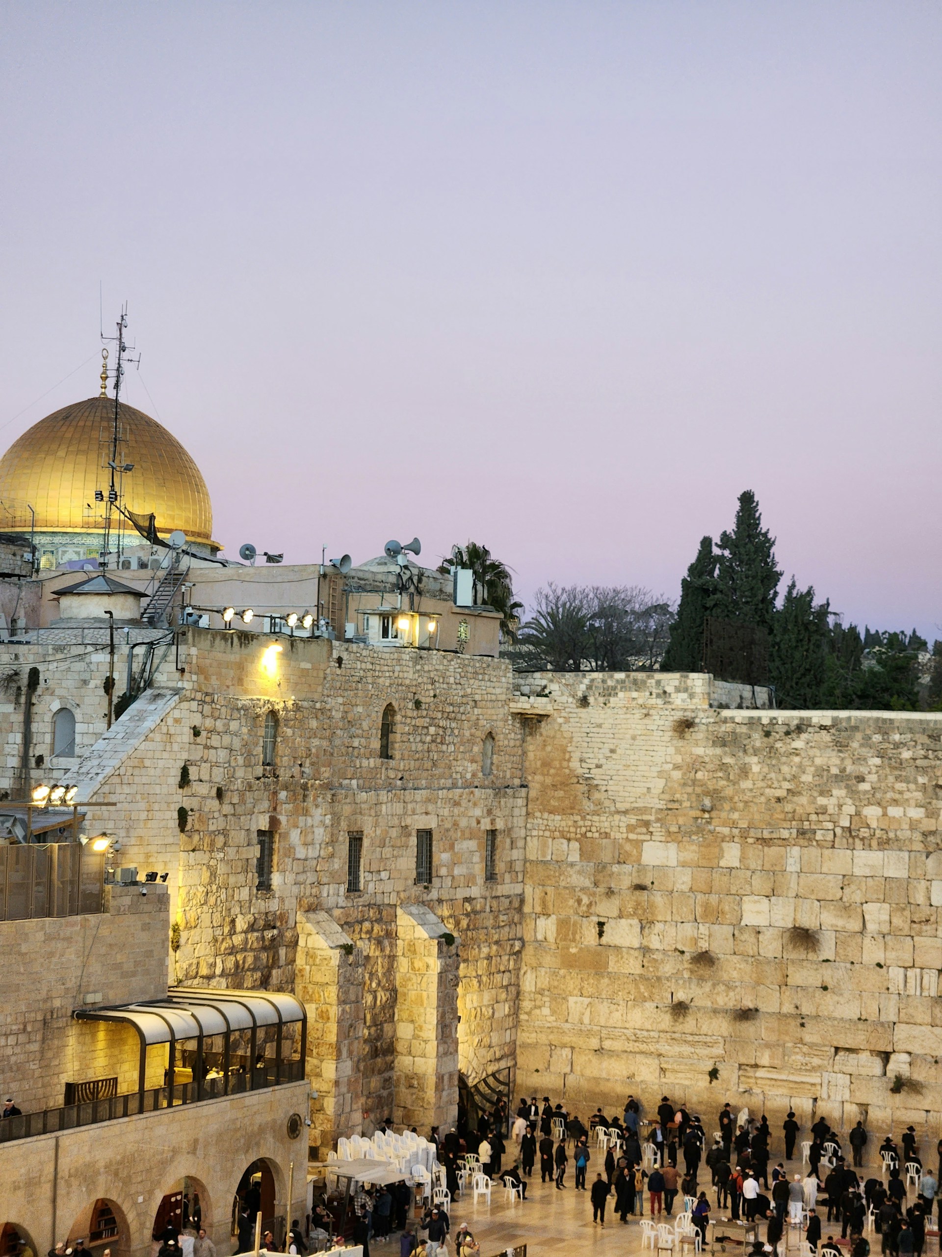 Sunlight casting golden hues over the Dome of the Rock, with pilgrims and visitors admiring its stunning architecture.