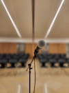 a microphone on a stand in front of a room full of chairs