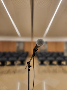 a microphone on a stand in front of a room full of chairs