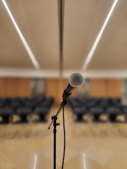 a microphone on a stand in front of a room full of chairs
