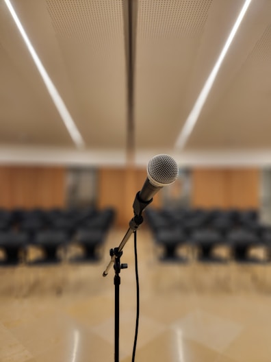 a microphone on a stand in front of a room full of chairs