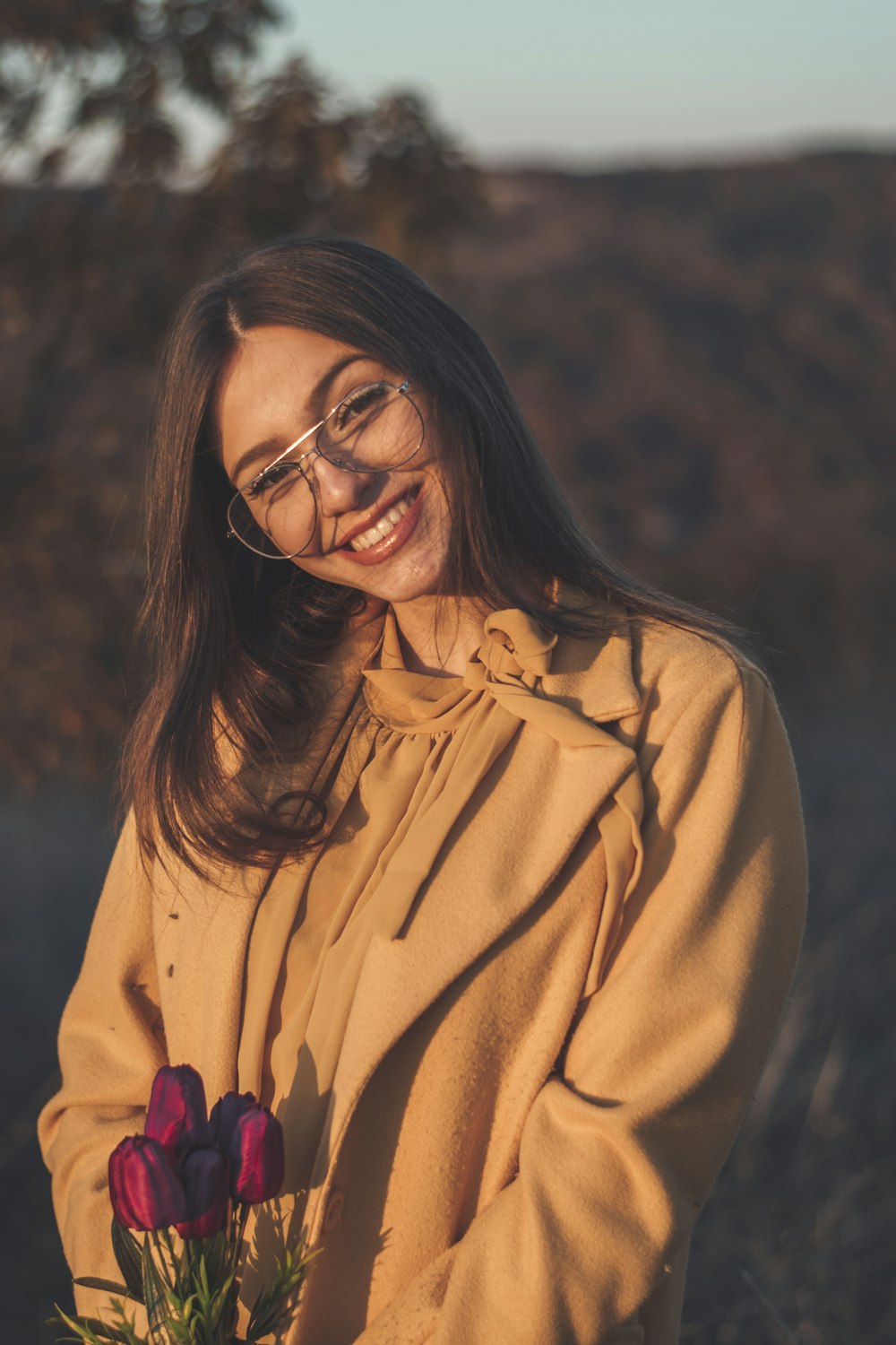 a woman wearing glasses holding a bouquet of flowers