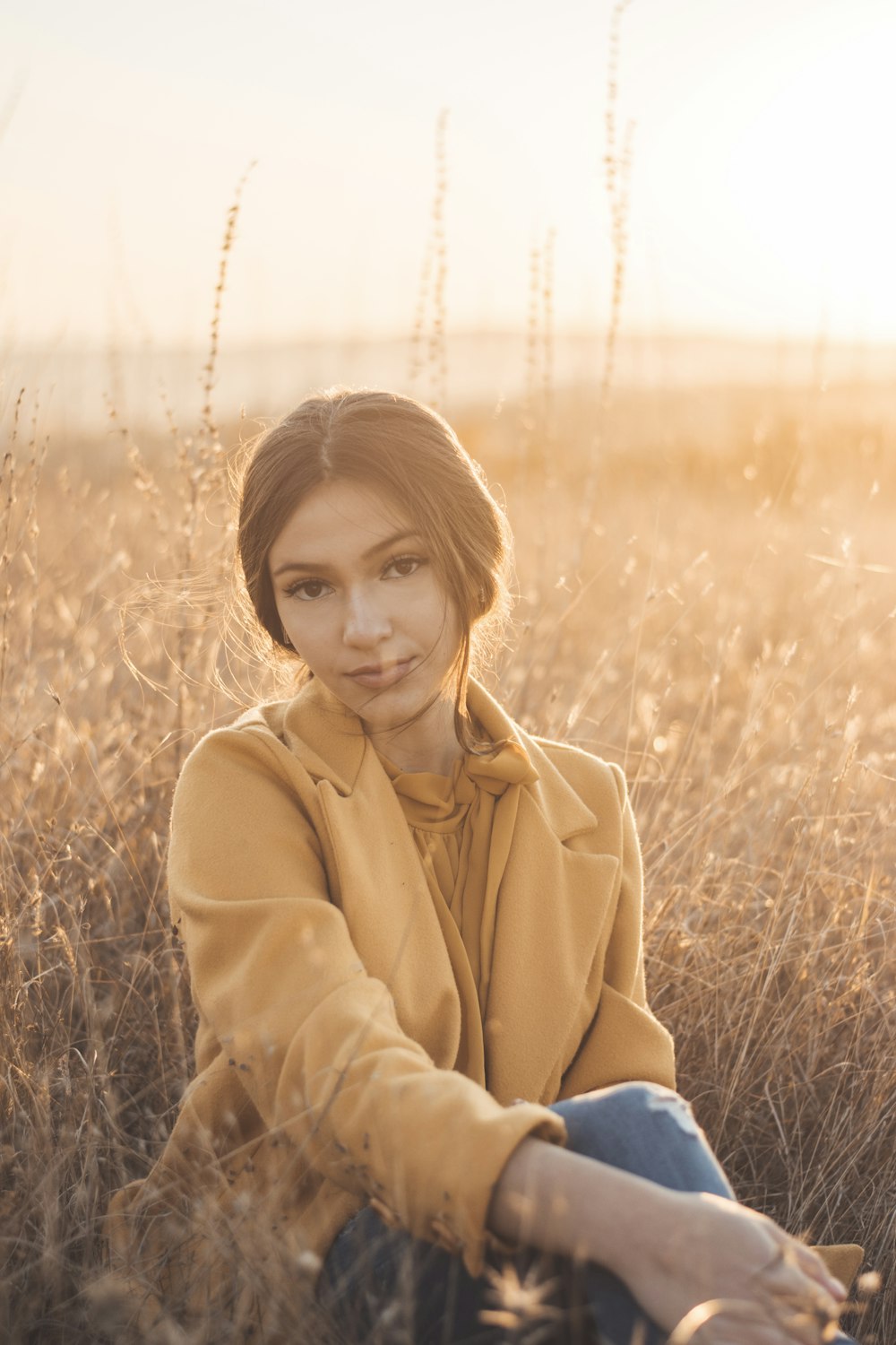 a woman sitting in a field of tall grass