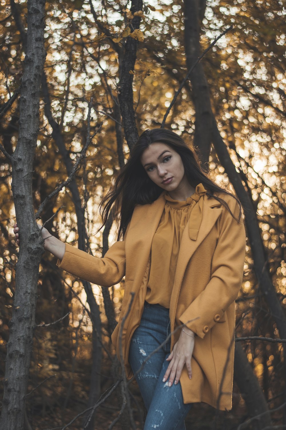 Une femme debout dans les bois avec ses mains sur ses hanches