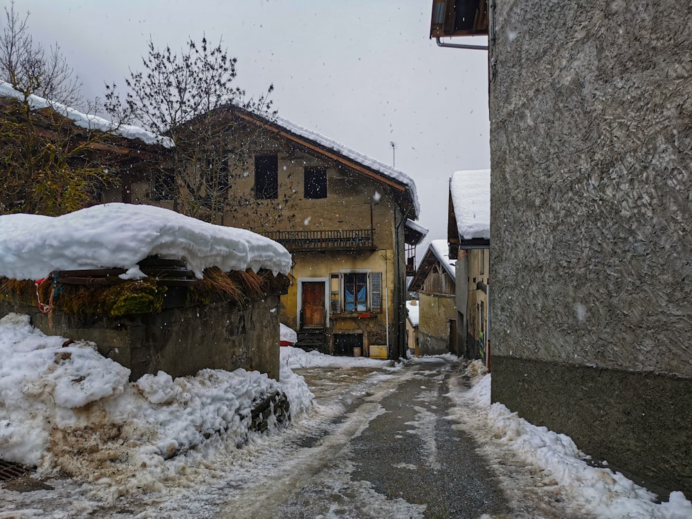 a street with snow on the ground and buildings in the background