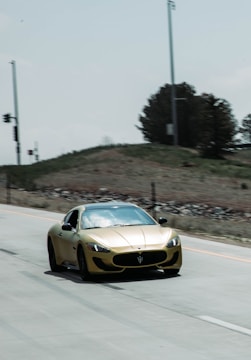 A sleek sports car gleaming under golden hour light on an open road.