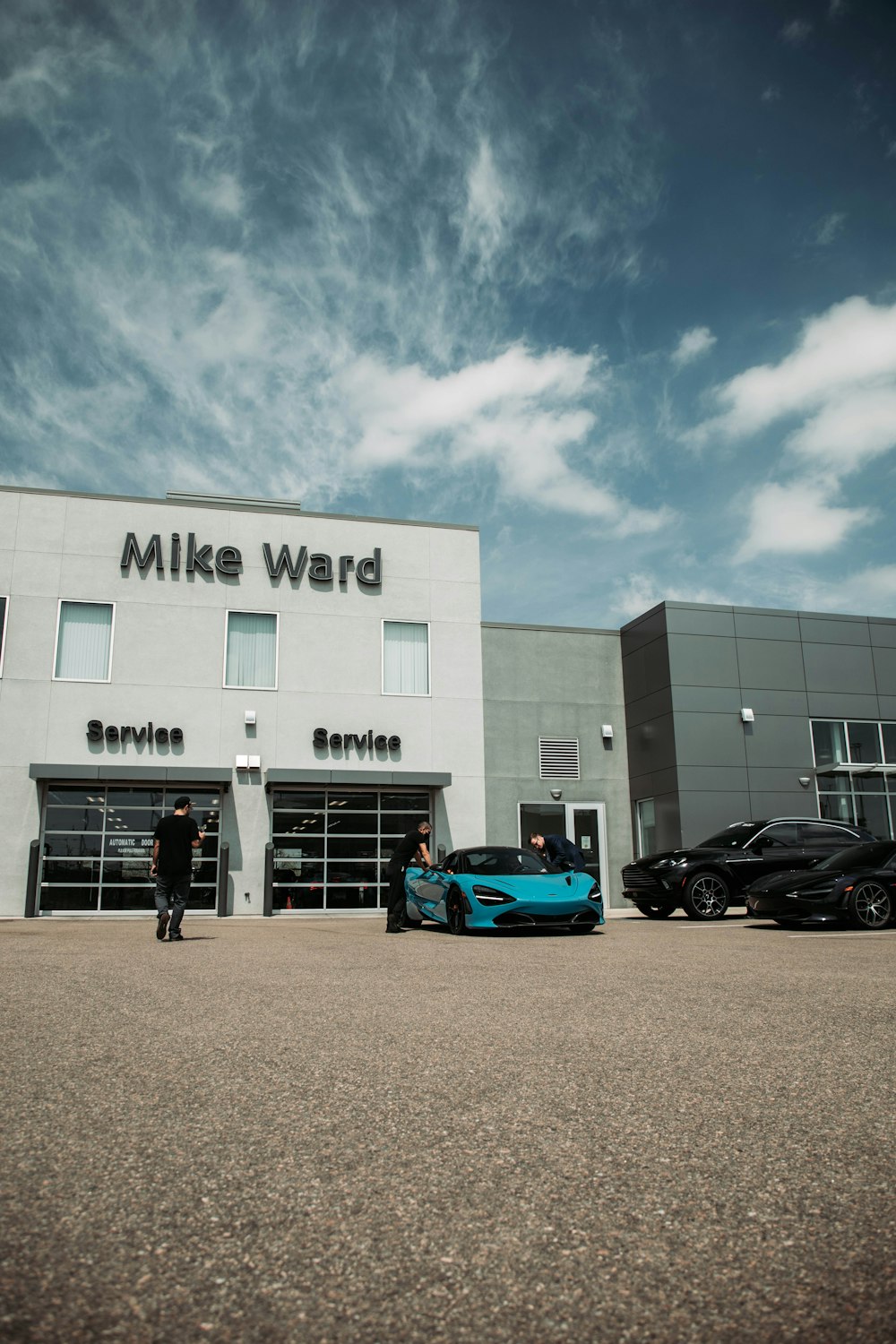 a blue sports car parked in front of a building