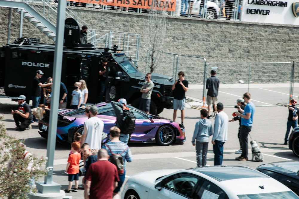 a group of people standing around a police car