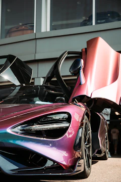 A dynamic card with neon magenta borders displaying a futuristic electric car model.