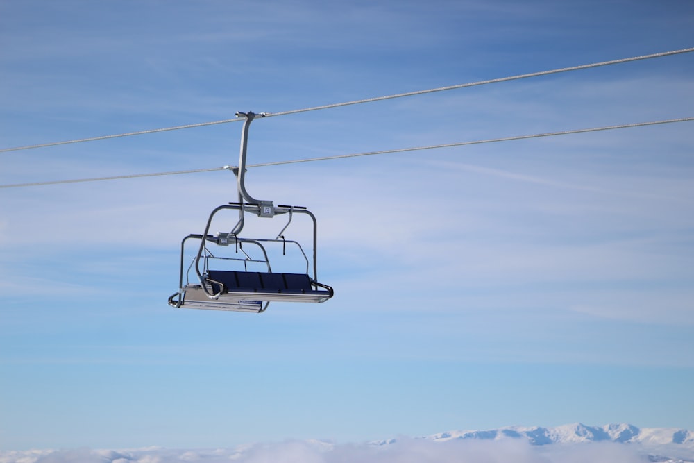a ski lift in the sky with a mountain in the background