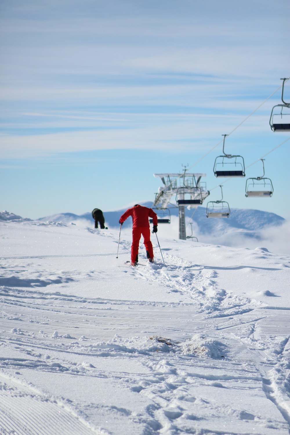 a person in a red suit skiing down a hill