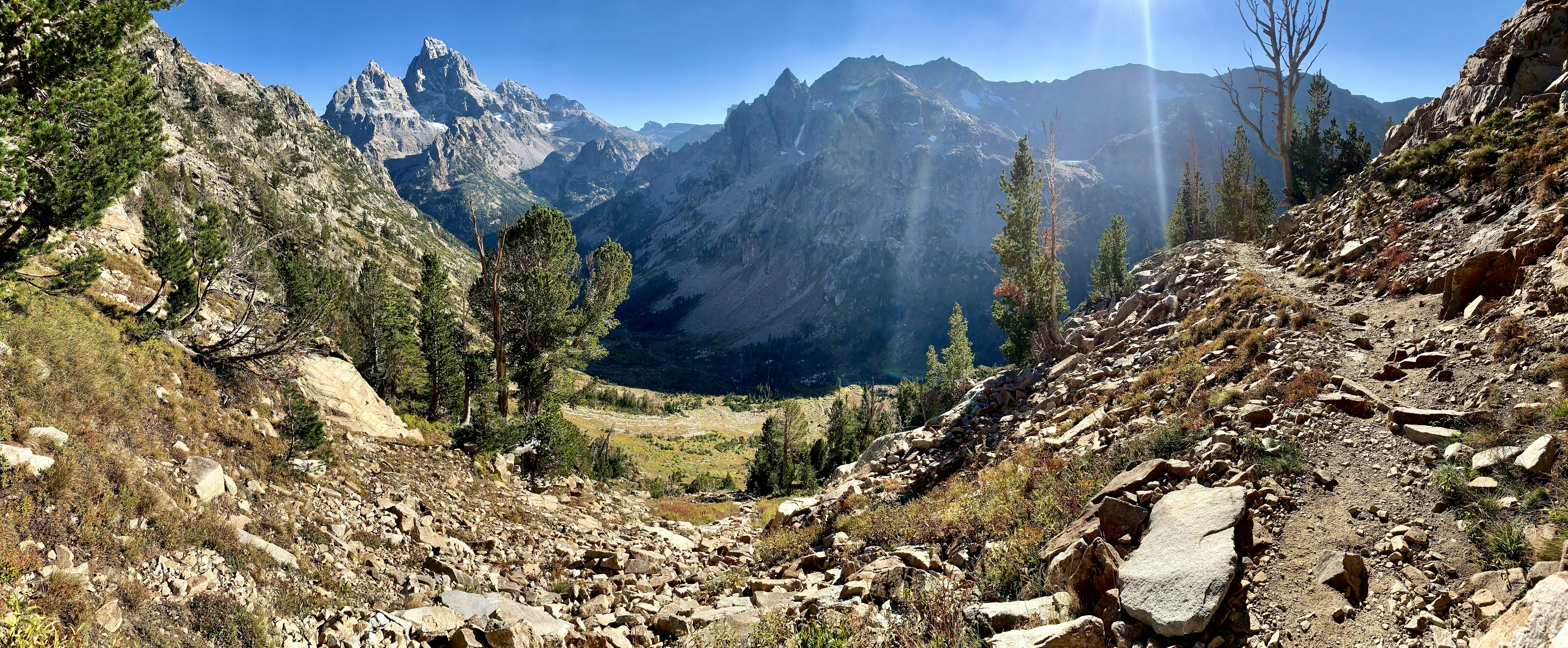 the sun shines brightly on a mountain valley