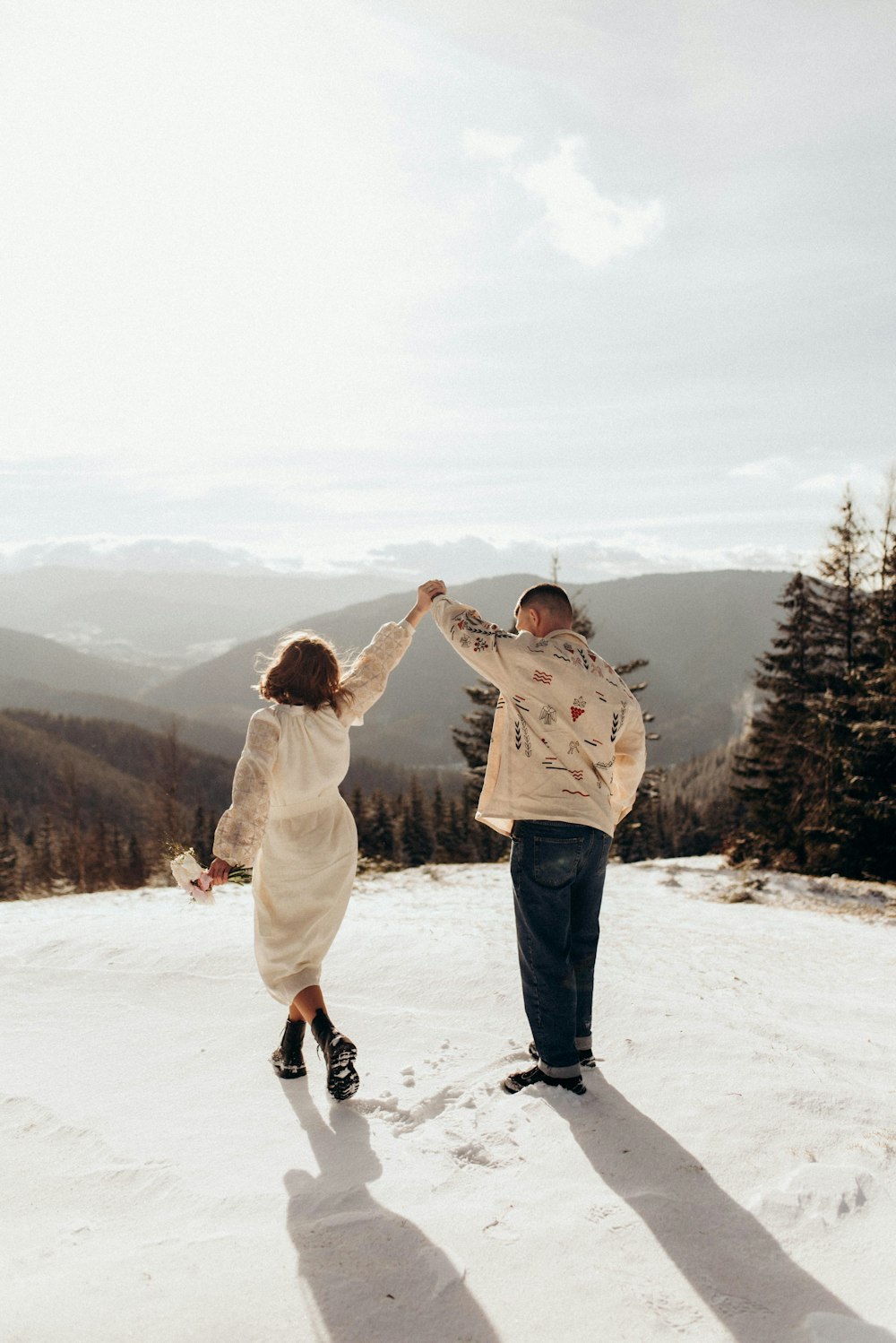 a man and a woman holding hands in the snow